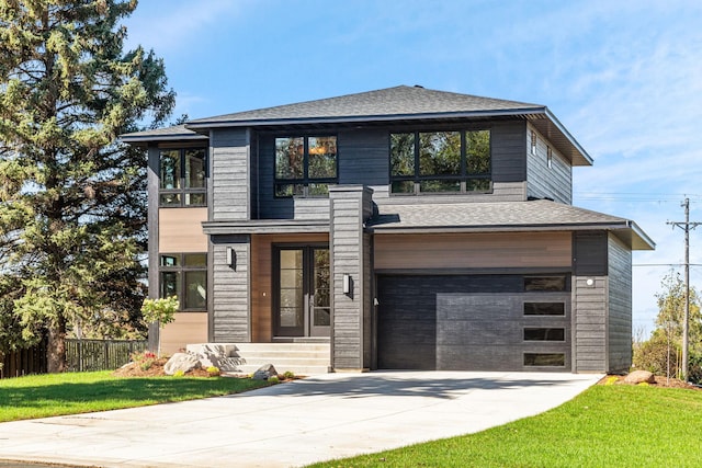 view of front of home featuring roof with shingles, fence, a garage, driveway, and a front lawn