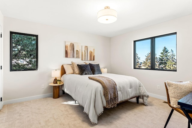 bedroom featuring light colored carpet and baseboards