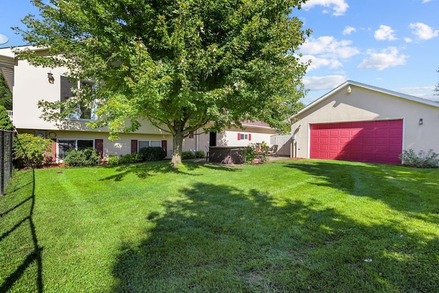 view of yard with a garage, driveway, and fence