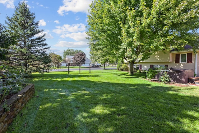 view of yard with a hot tub and fence