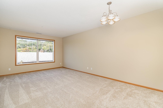 carpeted empty room with a chandelier