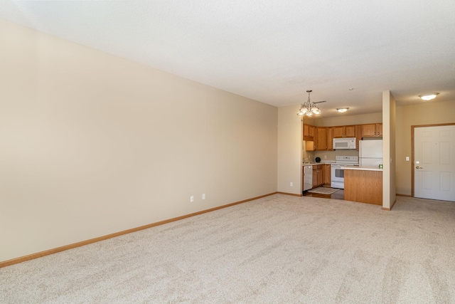 unfurnished living room featuring light colored carpet, a textured ceiling, and a chandelier