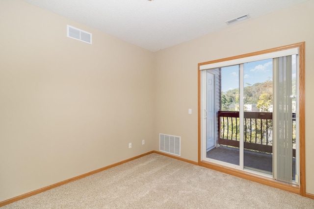 carpeted empty room featuring a textured ceiling