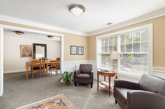 sitting room with ornamental molding, a textured ceiling, and carpet flooring