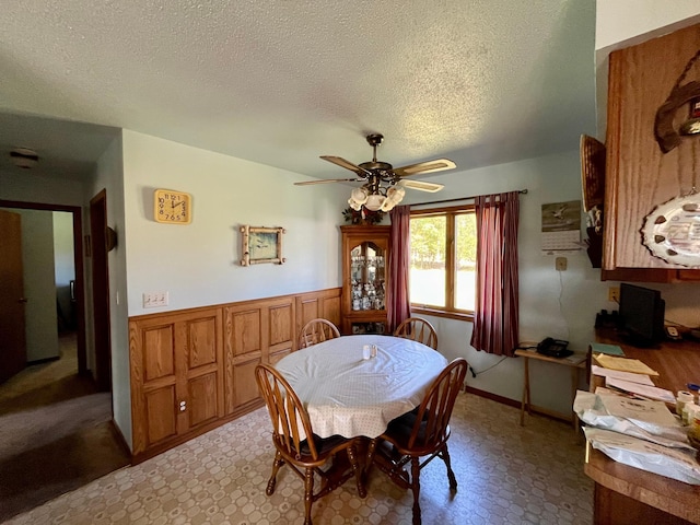 dining space with a textured ceiling and ceiling fan