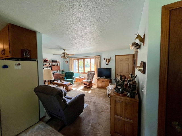 living room with a textured ceiling, light colored carpet, and ceiling fan