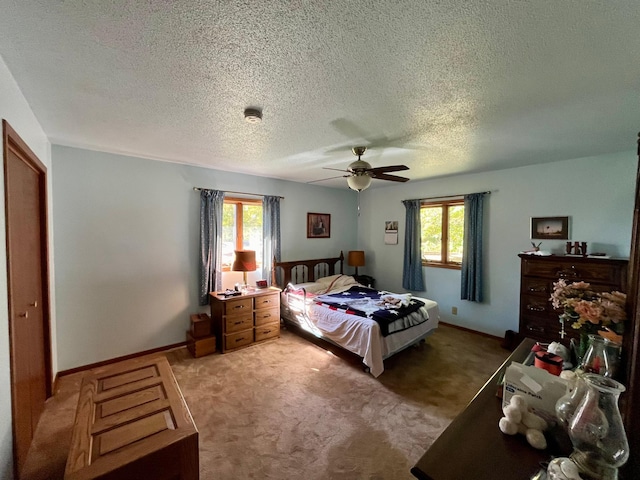 carpeted bedroom featuring ceiling fan, a textured ceiling, and multiple windows