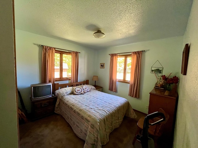 carpeted bedroom featuring multiple windows and a textured ceiling