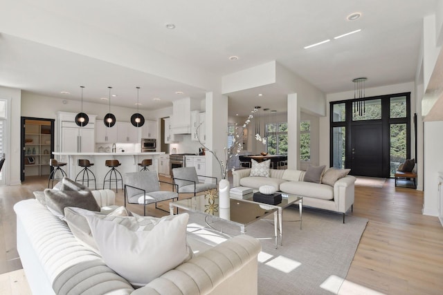 living room with light wood finished floors and recessed lighting