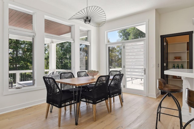 dining area featuring light wood-type flooring, baseboards, and visible vents