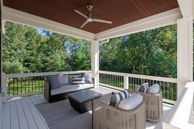 wooden deck with an outdoor living space and a ceiling fan