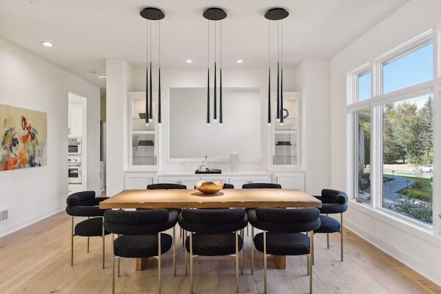 dining area with light wood-style floors, baseboards, and recessed lighting