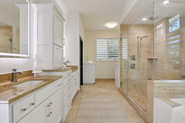 bathroom featuring tile patterned floors, a stall shower, two vanities, and a sink
