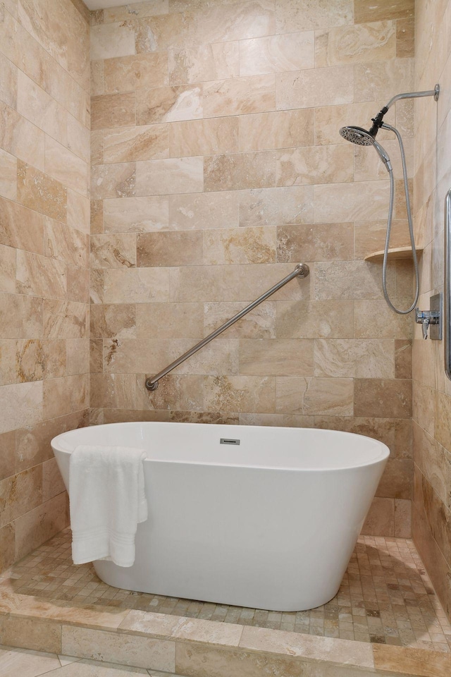 bathroom with tile walls, tiled shower, and a freestanding bath