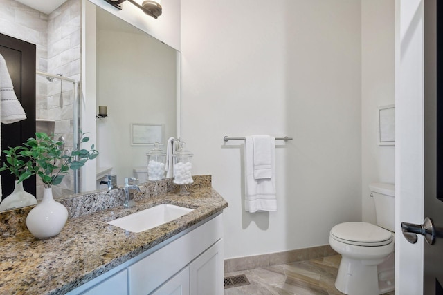 full bath featuring toilet, tiled shower, visible vents, baseboards, and vanity
