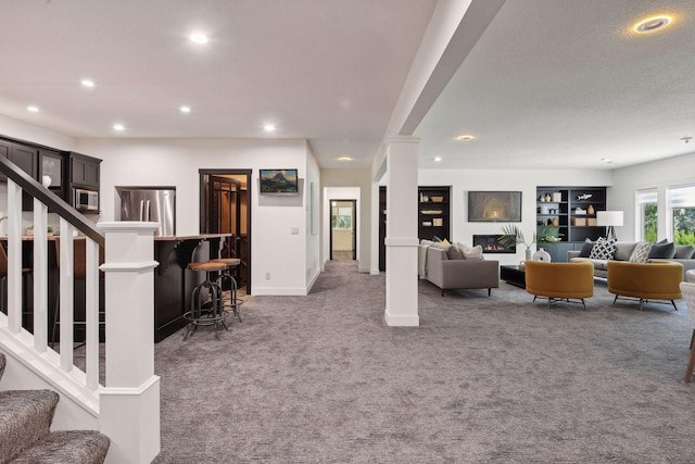 living area with stairs, ornate columns, recessed lighting, and carpet