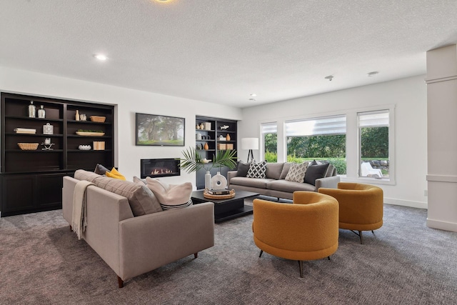 living room with a textured ceiling, carpet floors, a glass covered fireplace, and built in features