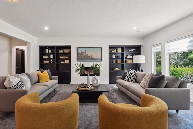 carpeted living area featuring a textured ceiling, recessed lighting, and built in features