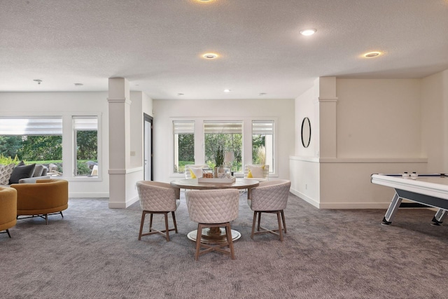 dining space with a textured ceiling, a wealth of natural light, and carpet