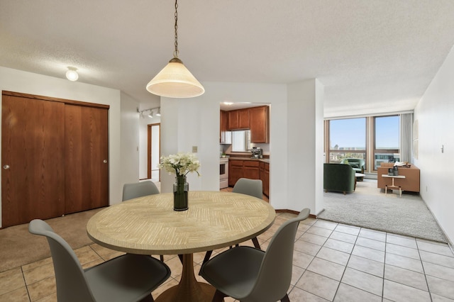 dining area featuring a textured ceiling and light carpet