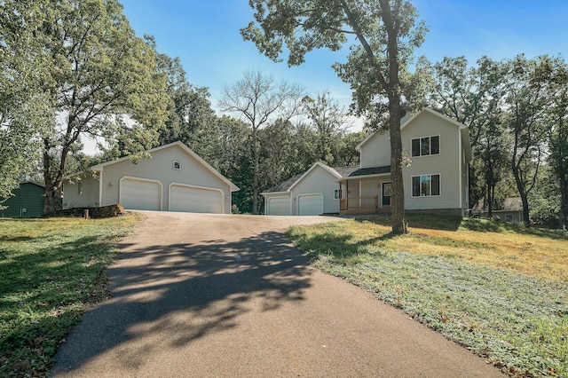 view of front of home featuring a front lawn, an outbuilding, and a garage