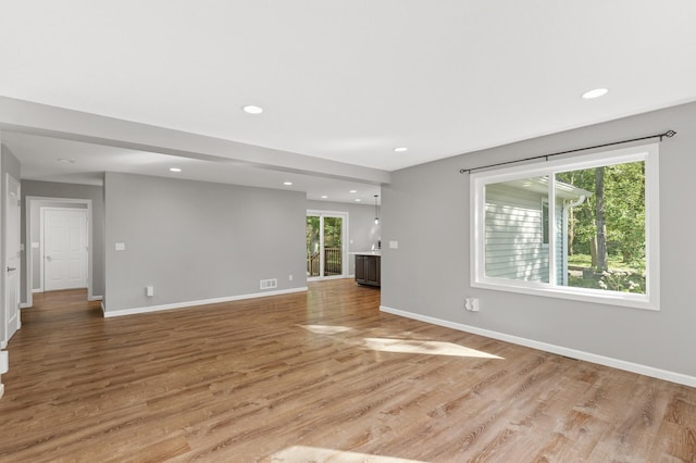 unfurnished living room featuring light hardwood / wood-style floors and plenty of natural light