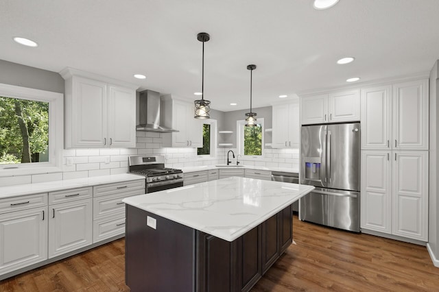 kitchen with wall chimney exhaust hood, white cabinetry, stainless steel appliances, a center island, and dark hardwood / wood-style flooring