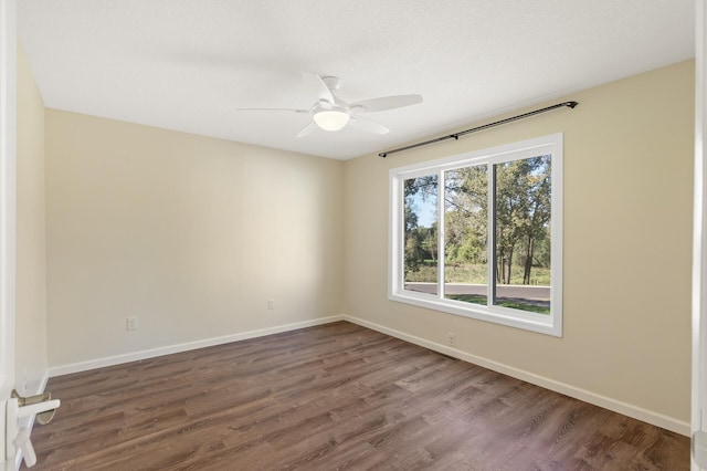 empty room with dark hardwood / wood-style flooring and ceiling fan