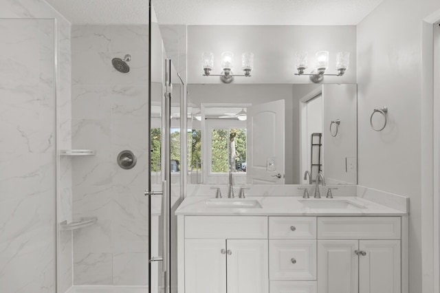 bathroom featuring a textured ceiling, vanity, and an enclosed shower