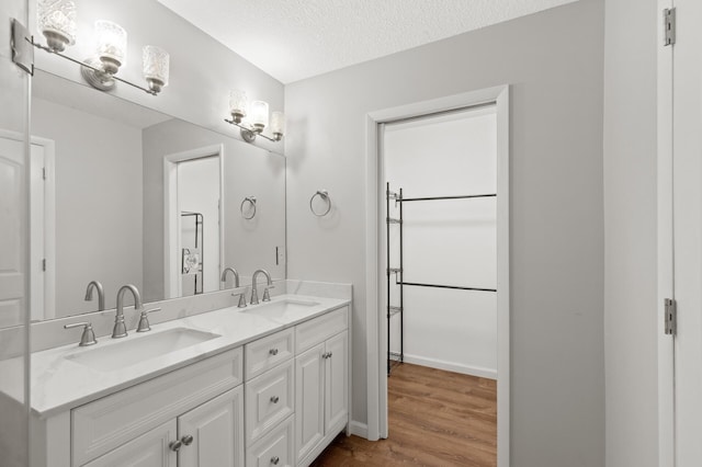 bathroom with hardwood / wood-style floors, a textured ceiling, and vanity