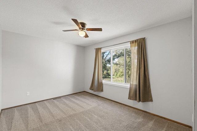 empty room with ceiling fan, carpet floors, and a textured ceiling