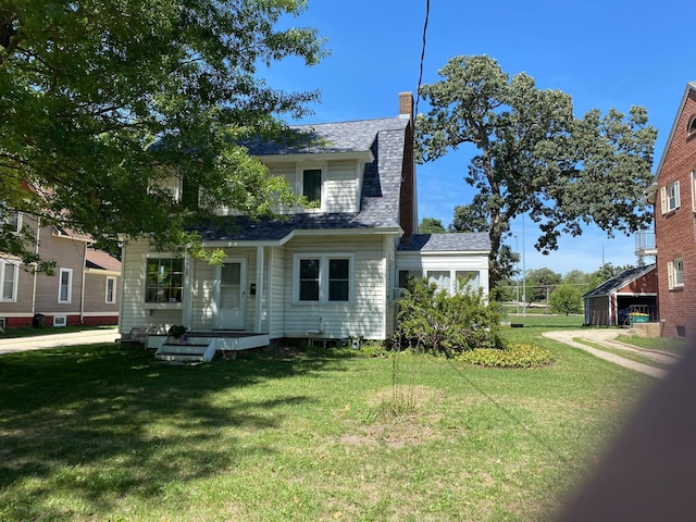 view of front of home with a chimney and a front yard
