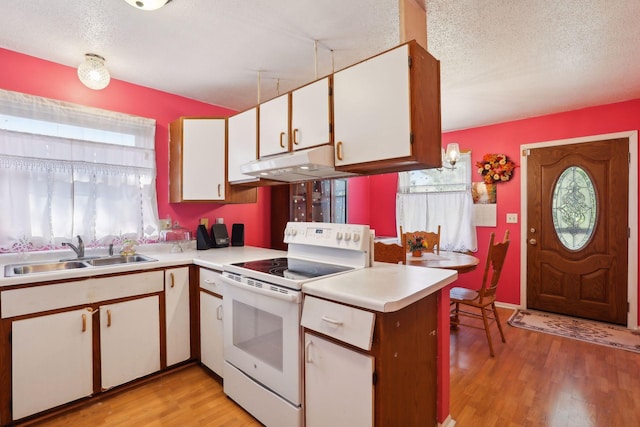 kitchen featuring electric stove, sink, white cabinetry, light hardwood / wood-style floors, and a textured ceiling