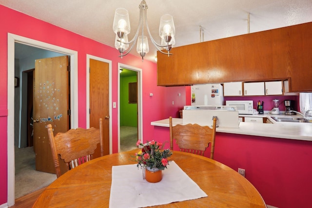 dining room with sink, a notable chandelier, and a textured ceiling