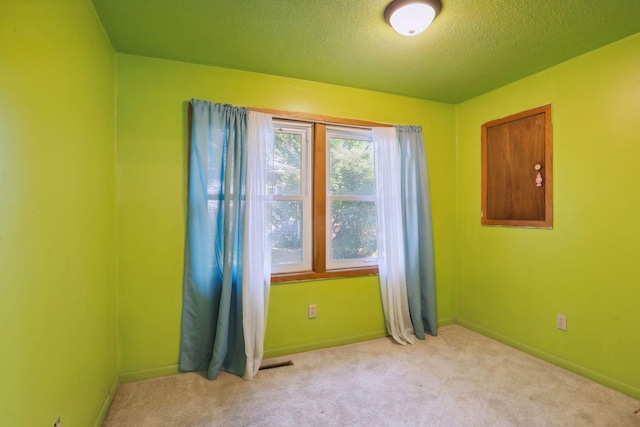 carpeted empty room with a textured ceiling