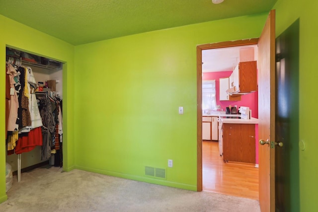 bedroom with light colored carpet and a closet