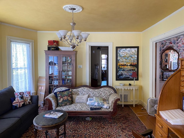 living room featuring ornamental molding, hardwood / wood-style floors, and a notable chandelier