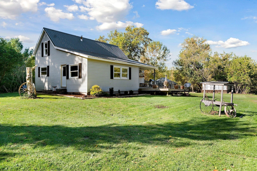 rear view of property featuring a deck and a lawn