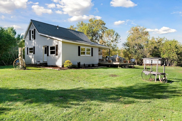 rear view of property featuring a deck and a lawn