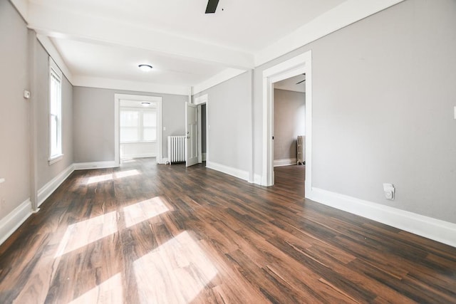 empty room with radiator, dark hardwood / wood-style flooring, and ceiling fan