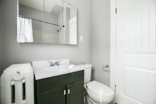 bathroom with a shower with shower curtain, vanity, and toilet