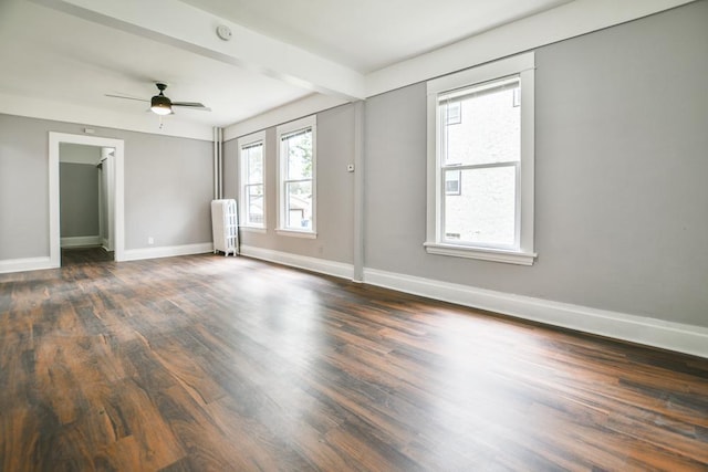 unfurnished room with ceiling fan, beam ceiling, dark hardwood / wood-style flooring, and radiator heating unit