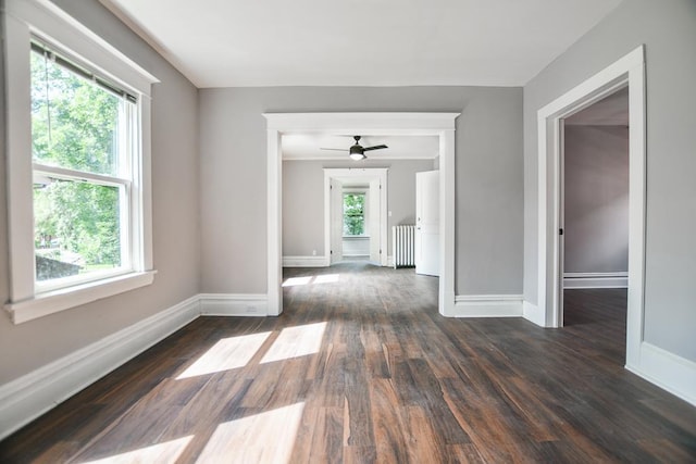 spare room featuring ceiling fan, plenty of natural light, dark hardwood / wood-style flooring, and radiator heating unit