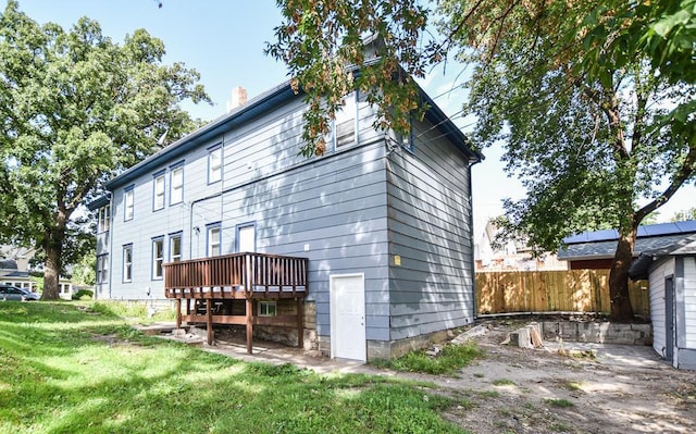 rear view of house with a wooden deck and a yard