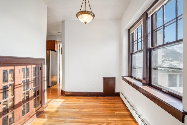 corridor with a baseboard radiator and light wood-type flooring