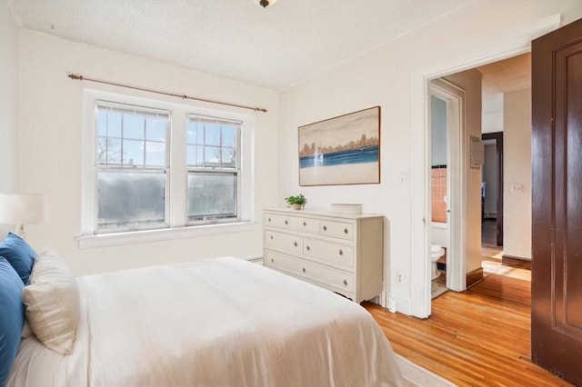 bedroom featuring light hardwood / wood-style flooring and a textured ceiling