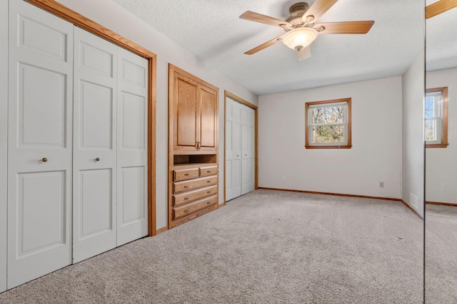 8011 Long Lake Rd, Mounds View, MN 55112 - unfurnished bedroom featuring light colored carpet, a textured ceiling, multiple closets, multiple windows, and ceiling fan