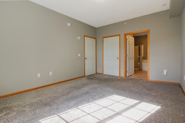 unfurnished bedroom with light carpet and ensuite bath