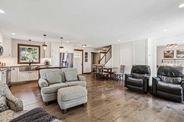 living room with stairway, a chandelier, dark wood-type flooring, and recessed lighting