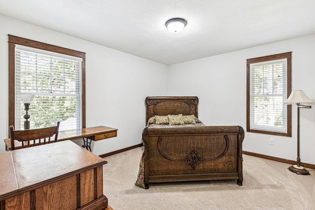 bedroom featuring light colored carpet, multiple windows, and baseboards